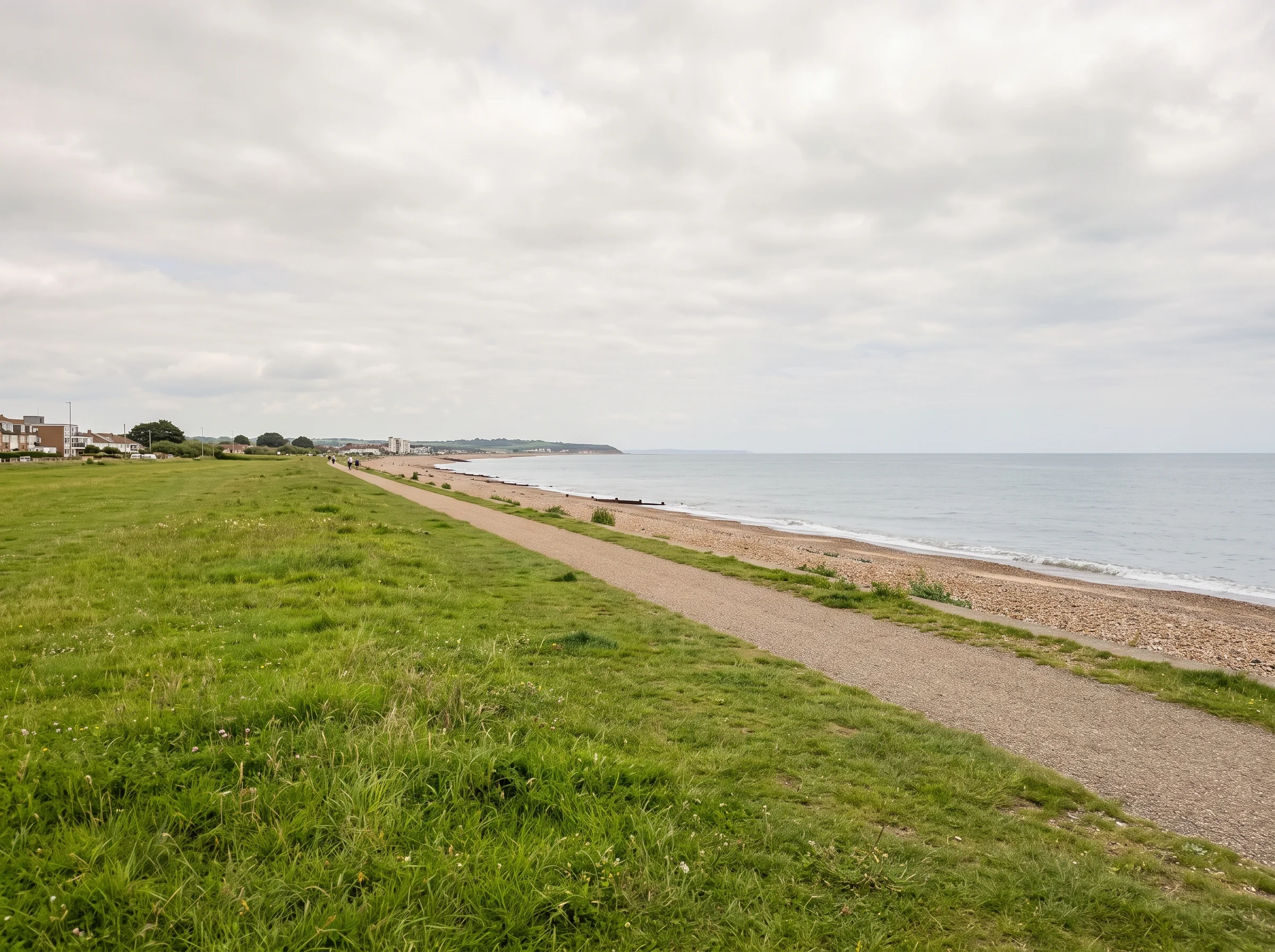 The Greensward at Goring, a long stretch of grass running beside the sea under a pale sky